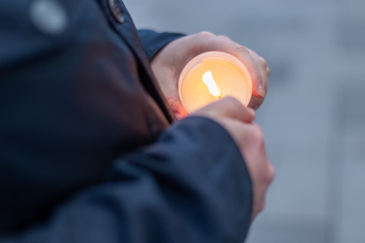 Hands holding a candle in a quiet moment of prayer